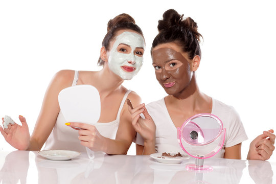 Two young women posing with face masks