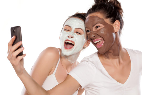 Two young women with masks making selfie