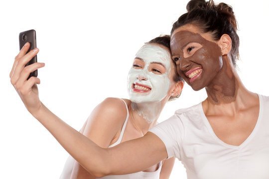Two young women with masks making selfie