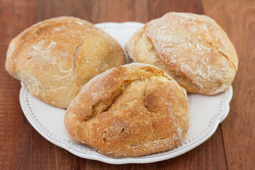 bread on white dish on brown background