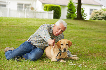 Älterer Mann mit Hund im Garten