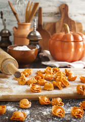Uncooked tortellini with cheese on a table