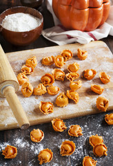 Uncooked tortellini with cheese on a table