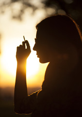 Girl Smoking at sunset in park