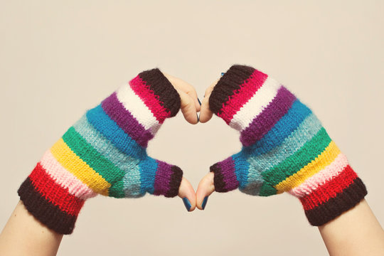 Female Hands In Colorful Knitted Gloves Gesturing Heart