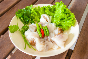 steamed rice-skin dumplings and vegetable on wooden table.