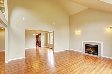 Empty living room with high ceiling and fireplace