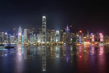 Fototapeten Night scene of Hong Kong with reflection on the sea © dcylai