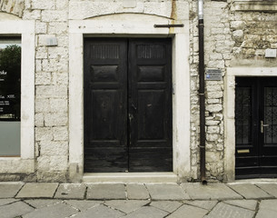 Fototapeta na wymiar Black wood doors. Different size. Old town.