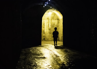 Silhouette of a boy in a dark tunnel