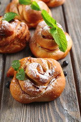 Tasty buns with berries on table close-up