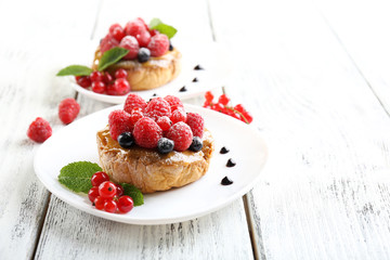 Sweet cakes with berries on table close-up