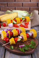 Sliced vegetables on picks on board on table close-up