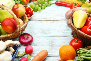 Fresh organic vegetables and fruits on wooden background