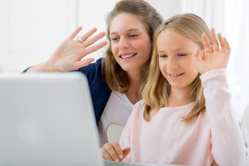 Attractive woman and little sister videocalling