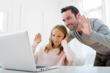 Father and his blond daughter using computer