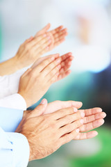 Clapping hands on bright background