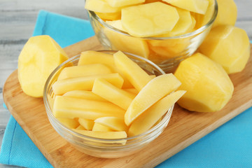 Raw peeled and sliced potatoes in glass bowls,