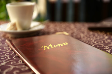 Menu book on table in restaurant