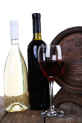 Wine in goblet and in bottles and wooden barrel