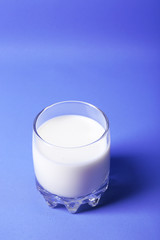 Milk in glass on blue background