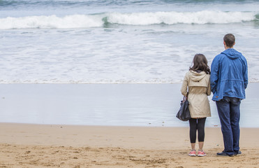 Pareja en la playa mirando al mar