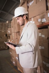 Manager with diary in warehouse