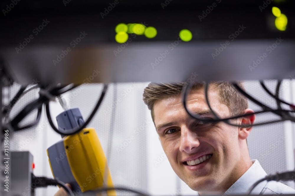 Aufkleber Smiling technician using digital cable analyzer on server