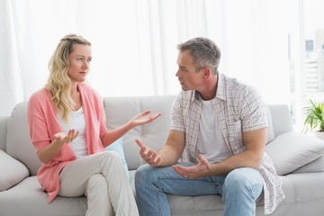 Unhappy couple having an argument on the couch