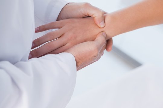 Male doctor examining a patients hand