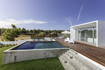Modern house with garden swimming pool and wooden deck