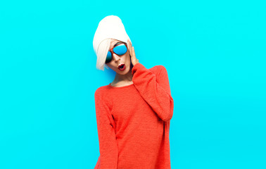 Portrait sexy blond model in red sweater on blue background. Stu