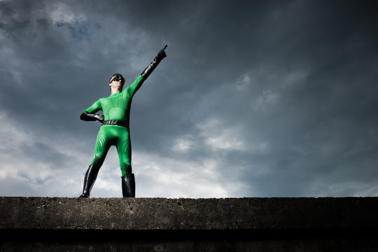 Superhero pointing with dramatic background