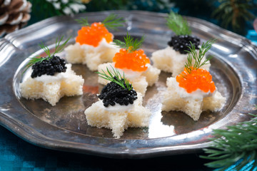 Christmas appetizers with caviar on a plate, close-up