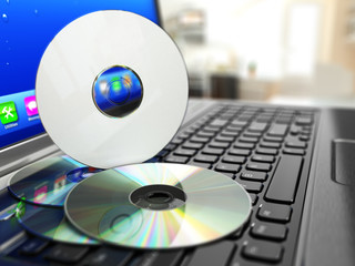 Software CD on laptop keyboard. Compact disks.