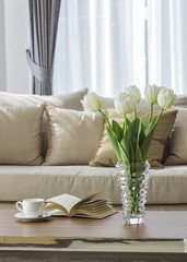 Living room sofa with coffee table book and flower