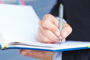 Female hand writing in notebook