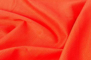 texture of bright, acid orange cloth with pleats