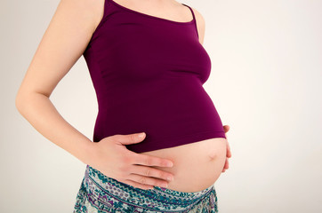  Closeup on woman holing her pregnant belly.Woman expecting baby