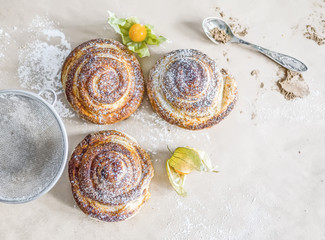 Cinnamon buns with sugar powder and ground cherry