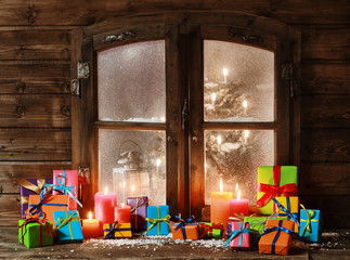 Assorted Christmas Presents and Candles at Window