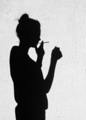  Shadow of girl smoking around on wall background