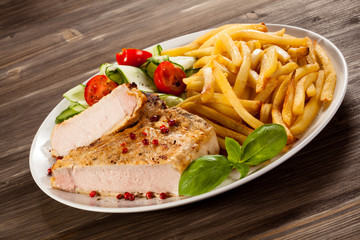Fried pork chop, chips and vegetable salad