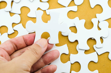 Jigsaw puzzle in hand on recycle paper background