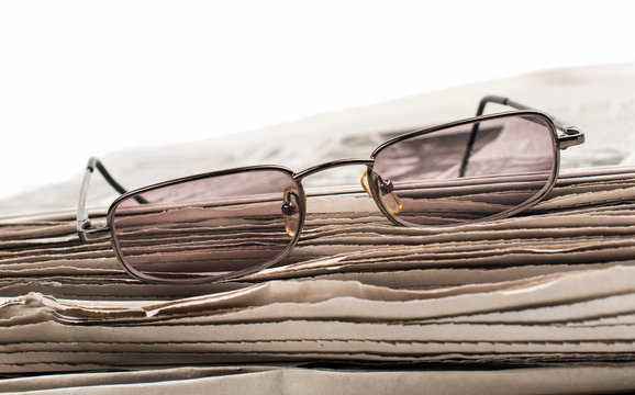 newspaper with glasses closeup