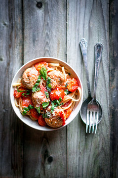 Pasta with meatballs on rustic background
