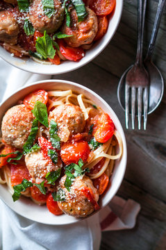 Pasta with meatballs on rustic background
