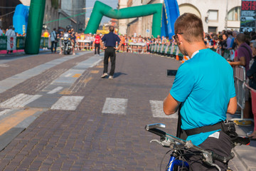 man with video camcorder and bike before city marathon