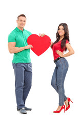 Young couple holding a big red heart