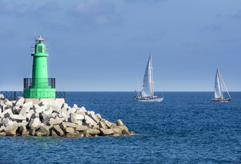 barche a vela costeggiano il faro
